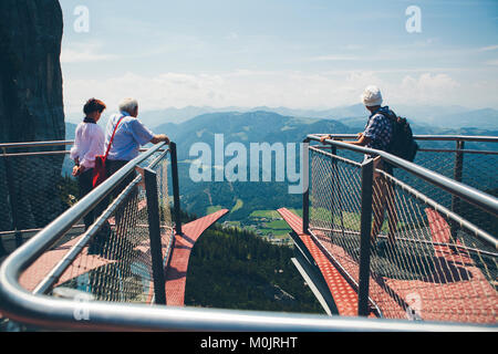 Touristen bewundern Sie die Aussicht von der Aussichtsplattform "Triassic Park" in den Alpen, in der Nähe von berg Steinplatte Waidring, Österreich. Stockfoto