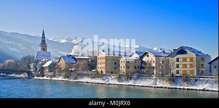 Reihe von Häusern mit Krankenhaus Kirche auf dem Inn im Winter, Schwaz, Tirol, Österreich Stockfoto