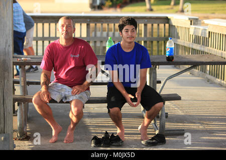 Vater und Sohn für ein Ziehen an ihren Angeln an der North Shore Park Fishing Pier in North Fort Myers, Florida, © katharine Andriotis Stockfoto