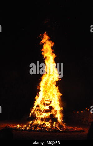 Ein Scout Lagerfeuer brennen hoch und hell in der Nacht. Sein warmes Licht bricht die Dunkelheit mit einem faszinierenden Glanz. Stockfoto