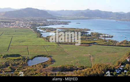 Kleine Stadt und Zuckerrohr-Felder auf Küste mit kleinen Inseln, von Hubschrauber, Savanne Bezirk der Republik Mauritius gesehen. Stockfoto