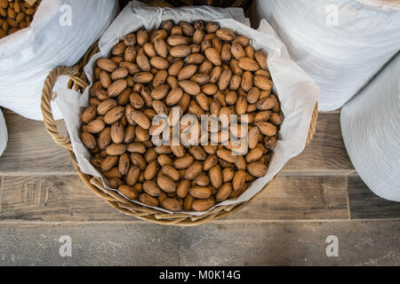 Unshelled Pekannüsse in einem Korb umhüllt mit weißer Leinwand textile, vor dem Speichern Stockfoto