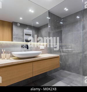 Badezimmer mit grauen lange Arbeitsplatte, Spiegel und begehbarer Dusche Stockfoto