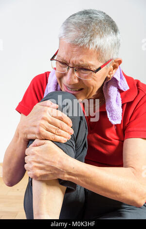 Ältere Dame erleben Knieschmerzen Stockfoto