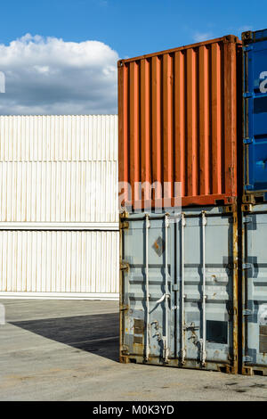 Abgenutzte intermodalen Container in einem Hof mit neueren weißen Palette breit und Kühlcontainer im Hintergrund gestapelt. Stockfoto