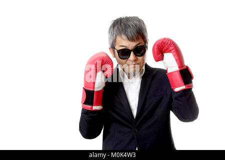 Die asiatische älterer Geschäftsmann mit Boxhandschuhen. Stockfoto