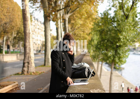 Spanischer Professor in freistehenden Pflicht arbeiten mit Laptop. Stockfoto