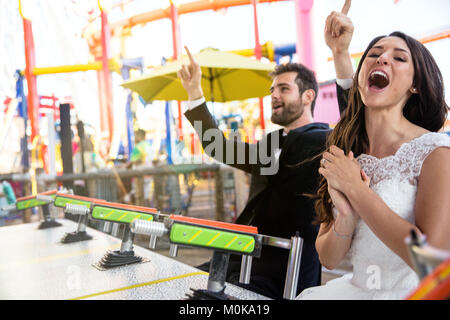 Junge nur verheiratete Braut und Bräutigam Lebensstil Lachen spielerisch Spaß an Theme Park Stockfoto