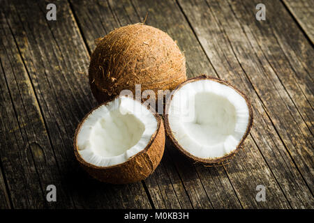 Die halbierte Kokosnüsse auf alten Holztisch. Stockfoto