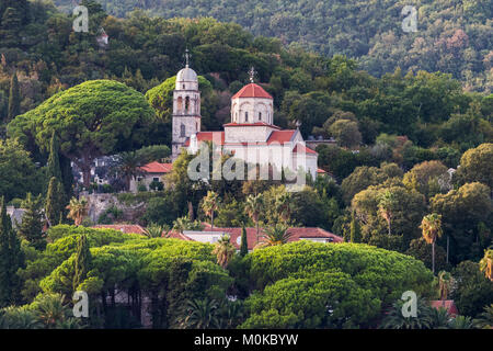 Eine Kirche und Gebäude auf einem Hügel umgeben von Bäumen; Herceg Novi, Montenegro Stockfoto