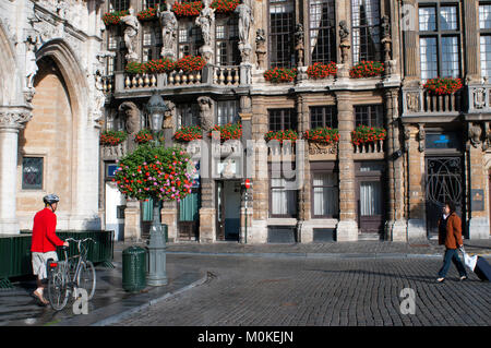 Ein Radfahrer und Hintergrund Gebäude Louve, Sac und Brouette. Grand Place, Brüssel, Belgien. Die louve, Sac und Brouette sind eine Gruppe von Häusern, die in der wer Stockfoto