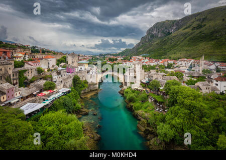 Luftbild der Altstadt von Mostar mit der berühmten alten Brücke (Stari Most) an einem regnerischen Tag mit dunklen Wolken im Sommer, Bosnien und Herzegowina Stockfoto