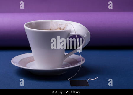 Porzellan weiße Tasse Tee auf dunkelblau ein lila Hintergrund Stockfoto