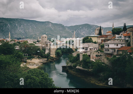 Klassische Ansicht der historischen Stadt Mostar mit der berühmten alten Brücke (Stari Most) an einem regnerischen Tag mit dunklen Wolken im Sommer, Bosnien und Herzegowina Stockfoto