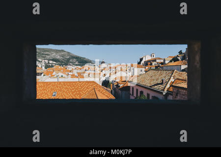 Durch ein Fenster an der rot gefärbten Terrakotta Dächer in der Altstadt von Dubrovnik im schönen Abendlicht bei Sonnenuntergang im Sommer, Kroatien Stockfoto