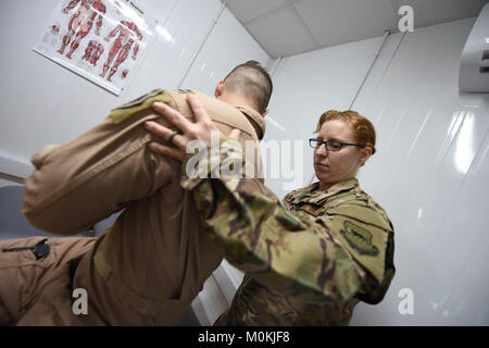 Oberstleutnant Tisha Sutton, 332 d Expeditionary Medical Group Physiotherapeuten, führt ein Pilot aus den 332 d Expeditionary Jagdgeschwader durch eine Reihe von Übungen Flexibilität am 3. Januar 2018 in Südwestasien. Schwere Überlebensmittel, erweiterte Flug Dauer und beengten Cockpits können für die Entwicklung von schweren Verletzungen führen zu bereitgestellt Aircrew Mitglieder ohne vorbeugende Pflege. (U.S. Air Force Stockfoto