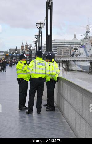 Die Metropolitan Police Officers tragen hohe Sichtbarkeit gelben Jacken und traditionellen coppers Helme in einer Gruppe stehen auf dem Beat an mehr London. Stockfoto