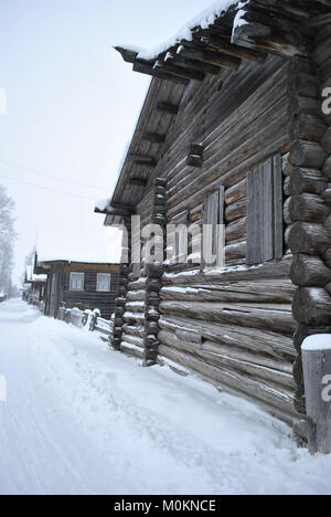 Traditionelles nordrussisches Holzhaus aus Rundholz. Winter im russischen Dorf Stockfoto