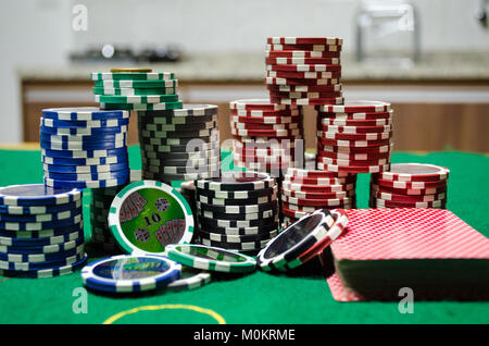 Poker Chips - Poker chips mit Karten auf einem grünen Tisch in Nahaufnahme Stockfoto