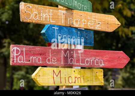 Holz- Schild in verschiedenen Farben zeigen unterschiedliche Richtungen zu Welt Städte und Strände - Saint Tropez, Teneriffa, Palma de Mallorca und Miami Stockfoto