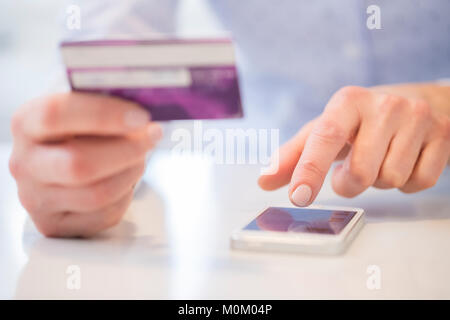 Nahaufnahme von Frau mit Kreditkarte zu kaufen auf dem Mobiltelefon Stockfoto