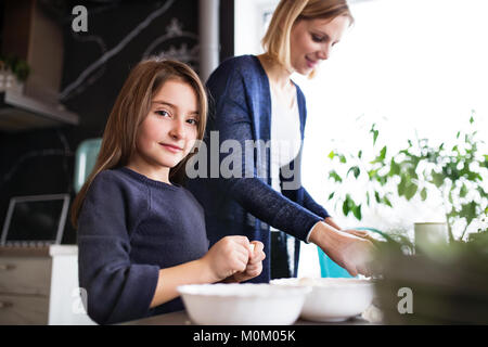 Ein kleines Mädchen mit ihrer Mutter kochen zu Hause. Stockfoto