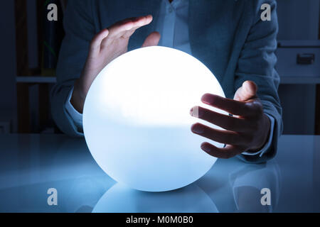 Porträt einer Afro-amerikanische Geschäftsfrau Hand auf Crystal Ball im Büro Stockfoto