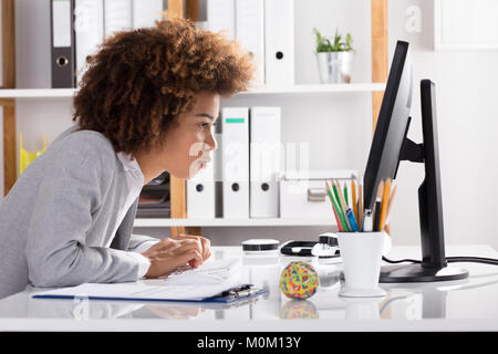 Seitenansicht eines Konzentration Junge Geschäftsfrau, Arbeiten am Computer im Büro Stockfoto