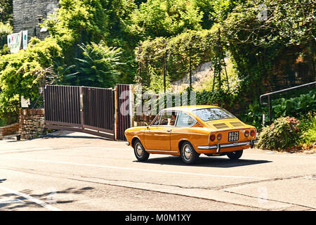 Junger Mann fahren Gelb vintage Fiat 850 Sport Coupe freigegeben circa 1970 in Italien. Stockfoto