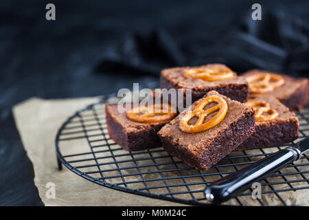 Hausgemachte Schokolade Brownies mit gesalzene Brezeln auf die Oberseite, Nahaufnahme, dunklen Hintergrund Stockfoto