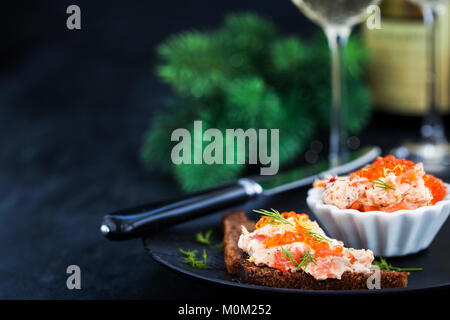 Lachs, Pastete (Rillettes) mit rotem Kaviar mit geschnittenem Brot serviert. Stockfoto