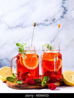 Eistee mit Orange und Himbeere in zwei Gläser und Minze Stockfoto
