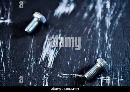 Muttern für Reparaturen liegen auf einem Holztisch. Stockfoto