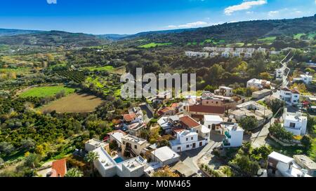 Antenne Blick aus der Vogelperspektive Goudi Dorf in Polis Chrysochous Tal, Paphos, Zypern. Blick auf traditionelle keramische Fliesen Dach Häuser, Kirche, Bäume, Hügel Stockfoto