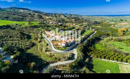 Aerial Blick aus der Vogelperspektive Goudi Dorf in Polis Chrysochous Tal, Paphos, Zypern. Blick auf traditionelle keramische Fliesen Dach Häuser, Bäume, Hügel und Ak Stockfoto