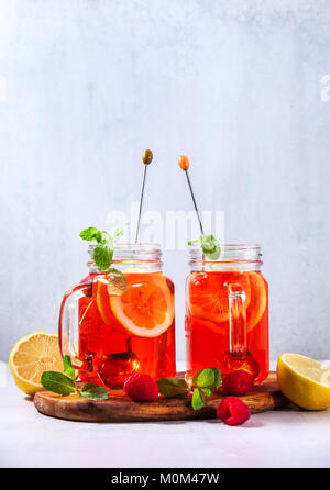 Eistee mit Orange und Himbeere in zwei Gläser und Minze Stockfoto