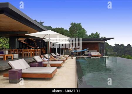 Costa Rica, Halbinsel Osa, Frau liegen auf einem Liegestuhl zwischen dem Restaurant mit zeitgenössischem Design dans der Infinity Pool der Ecolodge Kura Design Villas Stockfoto