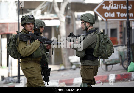 Hebron, West Bank, 23 Jan, 2018. Israelische Sicherheitskräfte nehmen Stellung bei Zusammenstößen mit palästinensischen Demonstranten in der Stadt Hebron, wie Protesten nach US Vizepräsidenten Bekräftigung der Dezember US Präsident Donald Trump 6 Erklärung von Jerusalem als Israels Hauptstadt ausbrach. Mike Pence versprach, die Botschaft zu den umstrittenen Stadt Jerusalem zu verschieben bis Ende 2019, während die Palästinenser mit einem Generalstreik und Proteste nach Kündigung seiner inbrünstig pro-Israel Rede am Tag zuvor als ''Messianic Cred reagiert. Stockfoto