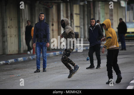 Hebron, West Bank Stadt Hebron. 23 Jan, 2018. Palästinensische Demonstranten werfen Steine auf israelische Soldaten während der Auseinandersetzungen nach einem Protest gegen den Besuch von US-Vizepräsident Mike Pence in Jerusalem in die West Bank von Hebron, Jan. 23, 2018. Credit: Mamoun Wazwaz/Xinhua/Alamy leben Nachrichten Stockfoto