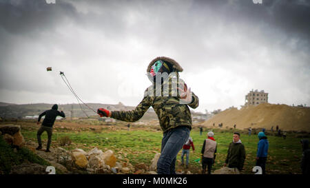 Beit EL, Palästina, 23. Jan 2018. palästinensische Demonstranten werfen Steine auf die israelischen Truppen während der Auseinandersetzungen mit der israelischen Sicherheitskräfte in der Nähe der jüdischen Siedlung Beit EL, am Rande der Stadt Ramallah im Westjordanland. Credit: eyad Jadallah/ImagesLive/ZUMA Draht/Alamy leben Nachrichten Stockfoto