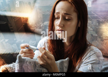 Traurig rothaarige Frau weinen und Halten der Thermometer. Stockfoto