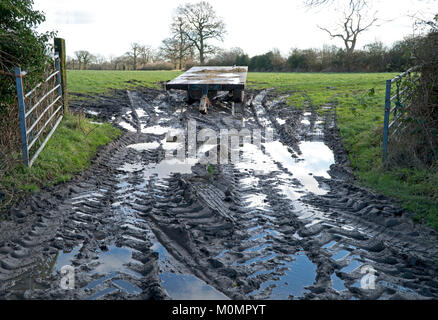 Eingang zu einem schlammigen Bauernhof Feld mit offenen Toren. In einem Land Lane im ländlichen England nach Regen Sturm genommen. Stockfoto