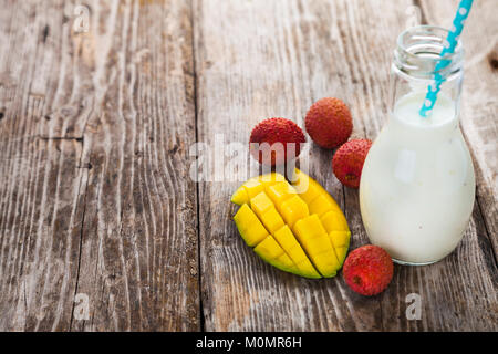 Smoothies mit tropischen Früchten auf einem hölzernen Hintergrund. Leckeres Frühstück. Das gesunde Essen. Stockfoto