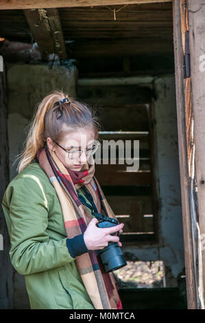 Junge Blondine mit Kamera, Prag, Tschechien, 20. Januar 2018, überprüft den aufgenommenen Bilder Stockfoto