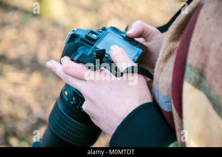 Junge Blondine mit Kamera, Prag, Tschechien, 20. Januar 2018, überprüft den aufgenommenen Bilder Stockfoto