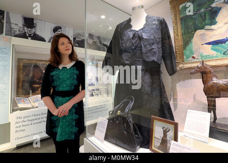 Katherine Carter, Kurator am Chartwell, der ehemaligen Heimat von Sir Winston Churchill und seine Frau Clementine in Kent, Ansichten ein Abendkleid getragen von Clemintine während einer Vorschau der Chartwell winter Ausstellung, Clementine Churchill - sprechen für sich. Stockfoto