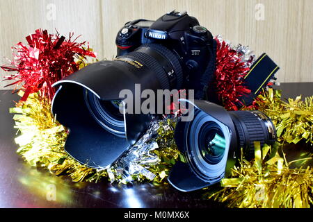 Nikon DSLR D80 und Akku und Linsen auf dem Display und Weihnachtsschmuck sowie Stockfoto