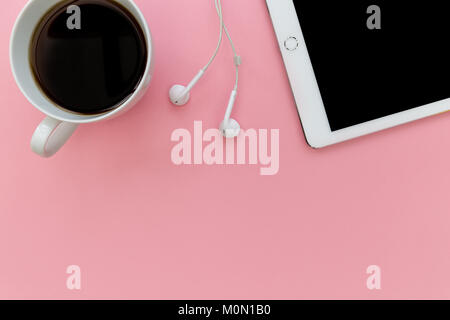 Weiße Tablette computer Kopfhörer und Kaffee Tasse Overhead auf Pastell rosa Hintergrund Stockfoto