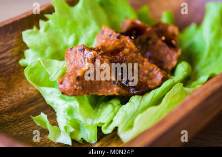 Türkische Lebensmittel cig Köfte mit Zitrone und Salat Salat und Petersilie auf Holzplatte Fach Stockfoto