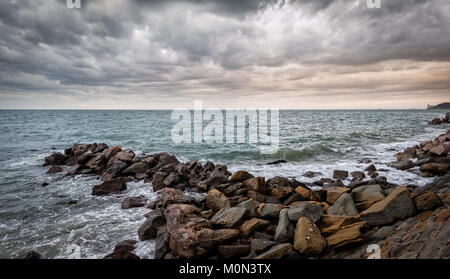 Wellen der Adria Absturz über eine künstliche Felsen unter stürmischen Himmel. Stockfoto